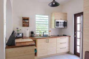 a kitchen with wooden cabinets and a microwave at Dream Beach House by Sonsoleá Host in Luquillo