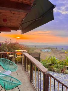 einen Balkon mit Stühlen, einem Tisch und Aussicht in der Unterkunft La Puesta Del Sol in Filandia