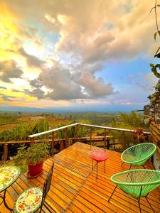 een houten terras met tafels en stoelen op een balkon bij La Puesta Del Sol in Filandia