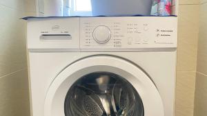 a white washer and dryer in a room at Miraflowers Home in Turin