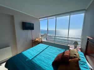 a bedroom with a bed and a view of the ocean at Estupendo Depto frente a Cochoa Reñaca in Viña del Mar