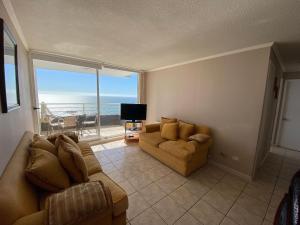 a living room with a couch and a view of the ocean at Estupendo Depto frente a Cochoa Reñaca in Viña del Mar