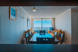 a living room with a dining table and a view of the ocean at Estupendo Depto frente a Cochoa Reñaca in Viña del Mar