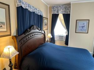 Un dormitorio con una cama azul y una ventana en Belmont Inn, en Shelbyville