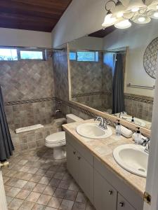 een badkamer met 2 wastafels, een toilet en een spiegel bij Awesome Castle Rock View! in Sedona
