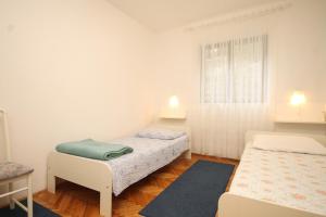 a bedroom with two beds and a window at Apartments by the sea Lukoran (Ugljan) - 8494 in Lukoran