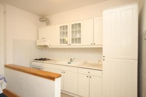 a kitchen with white cabinets and a sink at Apartments by the sea Lukoran (Ugljan) - 8494 in Lukoran