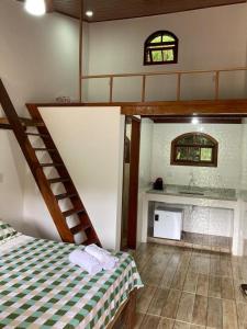 Habitación con escalera, cama y chimenea en Recanto Casa Amarela, en Miguel Pereira