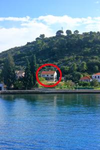 a house in a red circle next to a body of water at Apartments by the sea Kolocep, Elafiti - 2182 in Koločep