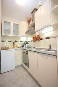 a white kitchen with white cabinets and appliances at Apartments by the sea Kolocep, Elafiti - 2182 in Koločep