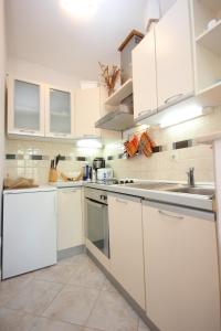 eine weiße Küche mit weißen Schränken und Geräten in der Unterkunft Apartments by the sea Kolocep, Elafiti - 2182 in Koločep