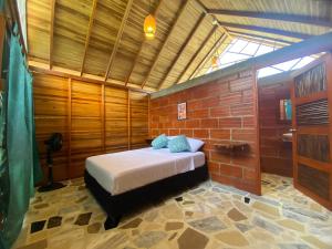 a bedroom with a bed in a brick wall at Casa kumake in El Zaino