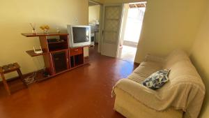 Casa recanto do mosteiro في ريبيراو بريتو: غرفة معيشة بها أريكة وتلفزيون