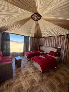 瓦迪拉姆的住宿－Karam Wadi Rum camp，一间卧室配有两张床和一张沙发。