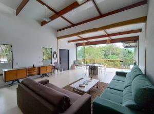 uma sala de estar com um sofá e uma mesa em Casa 3 suítes vista natureza em Ubatuba