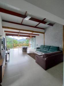 uma sala de estar com um sofá e uma mesa em Casa 3 suítes vista natureza em Ubatuba