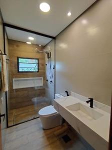 a bathroom with a toilet and a shower at Casa 3 suítes vista natureza in Ubatuba