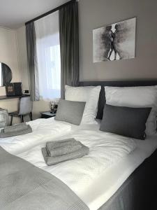 un grande letto bianco con due cuscini sopra di The Steakhouse - Guest Rooms a Sankt Johann im Pongau