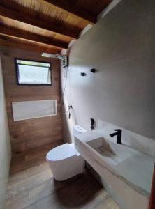 a bathroom with a white toilet and a sink at Casa 3 suítes vista natureza in Ubatuba