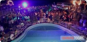 a crowd of people standing around a pool at a concert at Ca' Barabino in Genoa