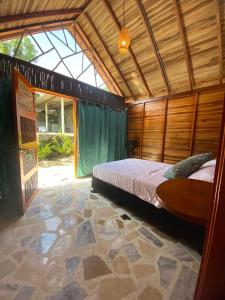 1 dormitorio con cama y ventana grande en Casa kumake en El Zaino