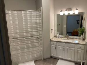 a bathroom with a shower and a sink and a mirror at Modern Luxury Fully Furnished 2BRM & 2Bath Downtown Atlanta Apartment in Atlanta