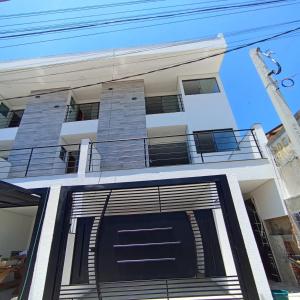 einen vorderen Blick auf ein Haus mit einer schwarzen Garage in der Unterkunft Ap 01 apartamento Beira mar in Pontal do Paraná