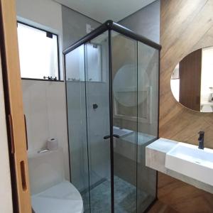 a bathroom with a glass shower and a sink at Ap 01 apartamento Beira mar in Pontal do Paraná