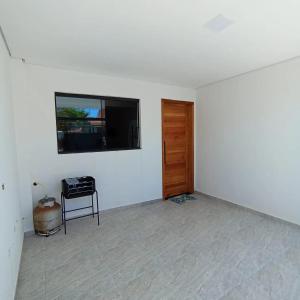 Habitación blanca con TV en la pared en Ap 01 apartamento Beira mar en Pontal do Paraná