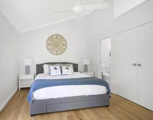 Macmasters BeachにあるFamily Friendly Beach House - 5mins walk to the beachの白いベッドルーム(大型ベッド1台、白いキャビネット付)