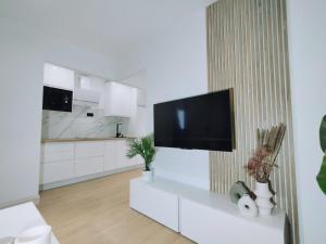 sala de estar con TV de pantalla plana en la pared en Apartamentos Franchy C derecho, en Telde
