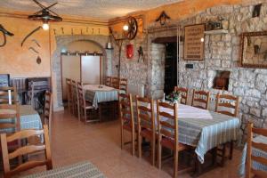 een eetkamer met tafels en stoelen en een stenen muur bij Apartments and rooms with a swimming pool Bacva, Central Istria - Sredisnja Istra - 7638 in Višnjan