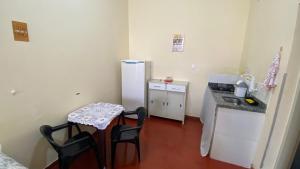 uma pequena cozinha com uma mesa e um frigorífico em Loft recanto do mosteiro em Ribeirão Preto