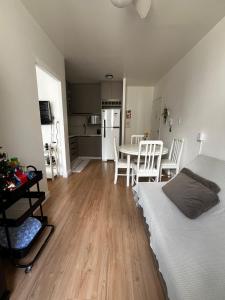 une chambre avec un lit et une cuisine avec une table dans l'établissement Apartamento central próximo da praia e atlântico shopping, à Balneário Camboriú