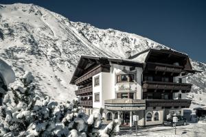 ein Gebäude vor einem schneebedeckten Berg in der Unterkunft Hotel Jagdhof Bed & Breakfast in Obergurgl