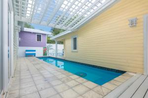 uma piscina com uma pérgula ao lado de uma casa em Casa Afortunada - 3 Bedrooms em Sandy Bay
