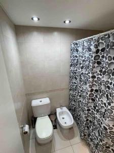 łazienka z toaletą i zasłoną prysznicową w obiekcie Montmartre Monserrat Buenos Aires w BuenosAires