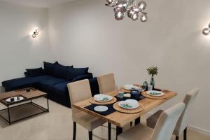a living room with a table and a blue couch at Modern 2BDRM in 5* Resort & pool in Sandanski