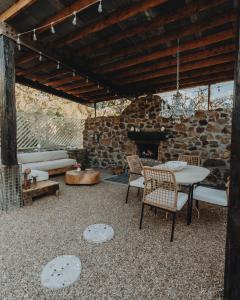 a patio with a table and chairs and a stone fireplace at Ona Geo Dome At El Mstico in Nogal
