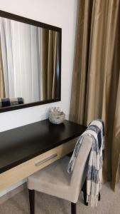 a dressing table with a mirror and a chair at Modern 2BDRM in 5* Resort & pool in Sandanski