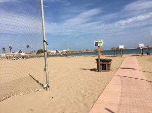 a volleyball net on a sandy beach with the ocean at Art riad au bord de la mer 2 in El Jadida