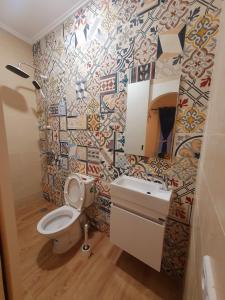 a bathroom with a toilet and a sink and a mirror at Art riad au bord de la mer 2 in El Jadida