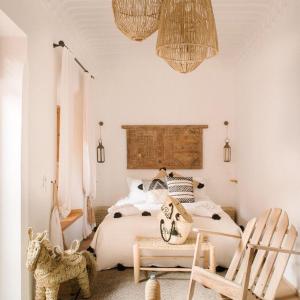 1 dormitorio con 1 cama, 2 sillas y lámparas de araña en Art riad au bord de la mer 2, en El Jadida
