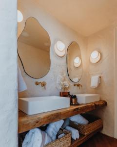 uma casa de banho com dois lavatórios e espelhos na parede em Ona Geo Dome At El Mstico em Nogal