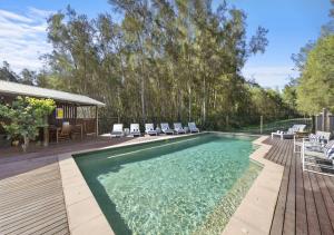 una piscina con sedie e tavolo e una casa di Sweetacres Hunter Valley a Pokolbin