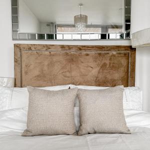 a bed with two pillows and a wooden headboard at Preciousluxurysuit in Bromley
