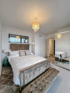 a bedroom with a large bed and a chandelier at Preciousluxurysuit in Bromley