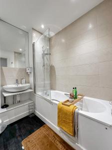 a bathroom with a tub and a sink at Preciousluxurysuit in Bromley