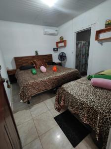 a room with two beds with leopard print sheets at Tortuguero Casa de Playa Green House in Tortuguero