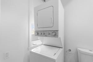 een witte badkamer met een wastafel en een spiegel bij Modern and cozy 4 bedrooms sleep 12 in Montreal